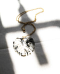 Collar dorado hoja monstera en blanco y negro