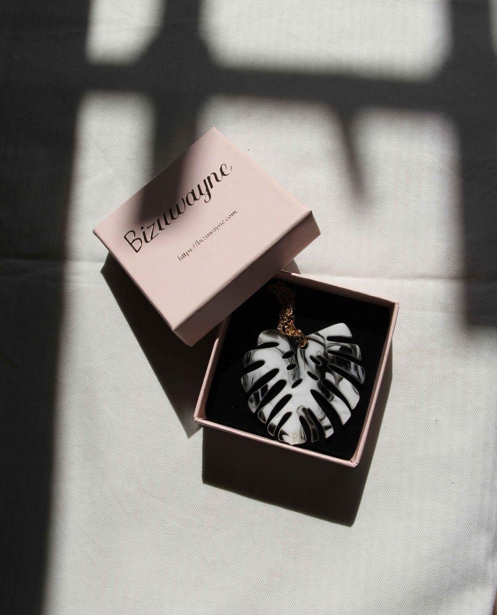 Collar dorado hoja monstera en blanco y negro